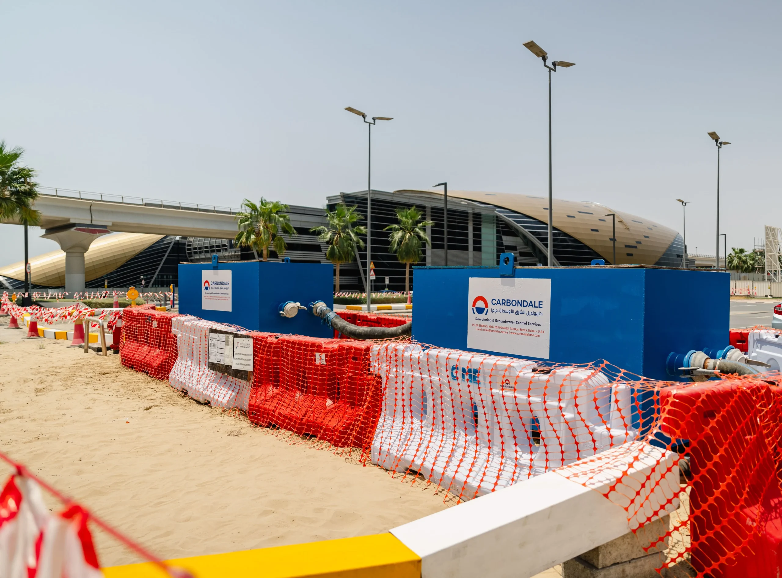 Roadside dewatering tanks installed for groundwater control during infrastructure construction.